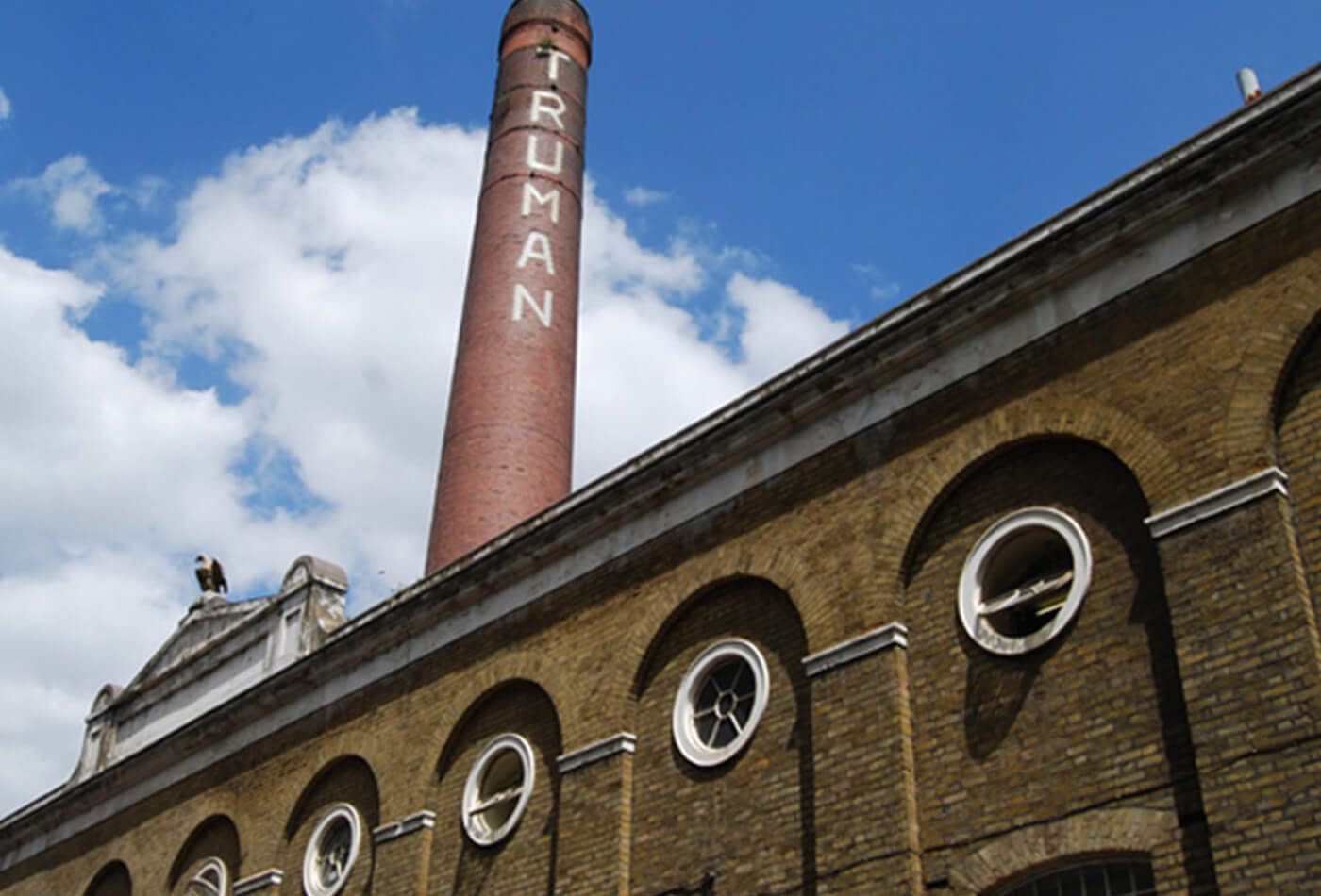Outdoor shot of building with large chimney and blue skies