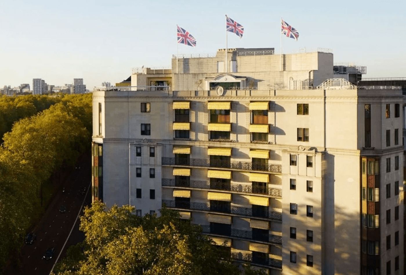 Large concrete hotel overlooking trees in the sunshine with a GB flag.jpg