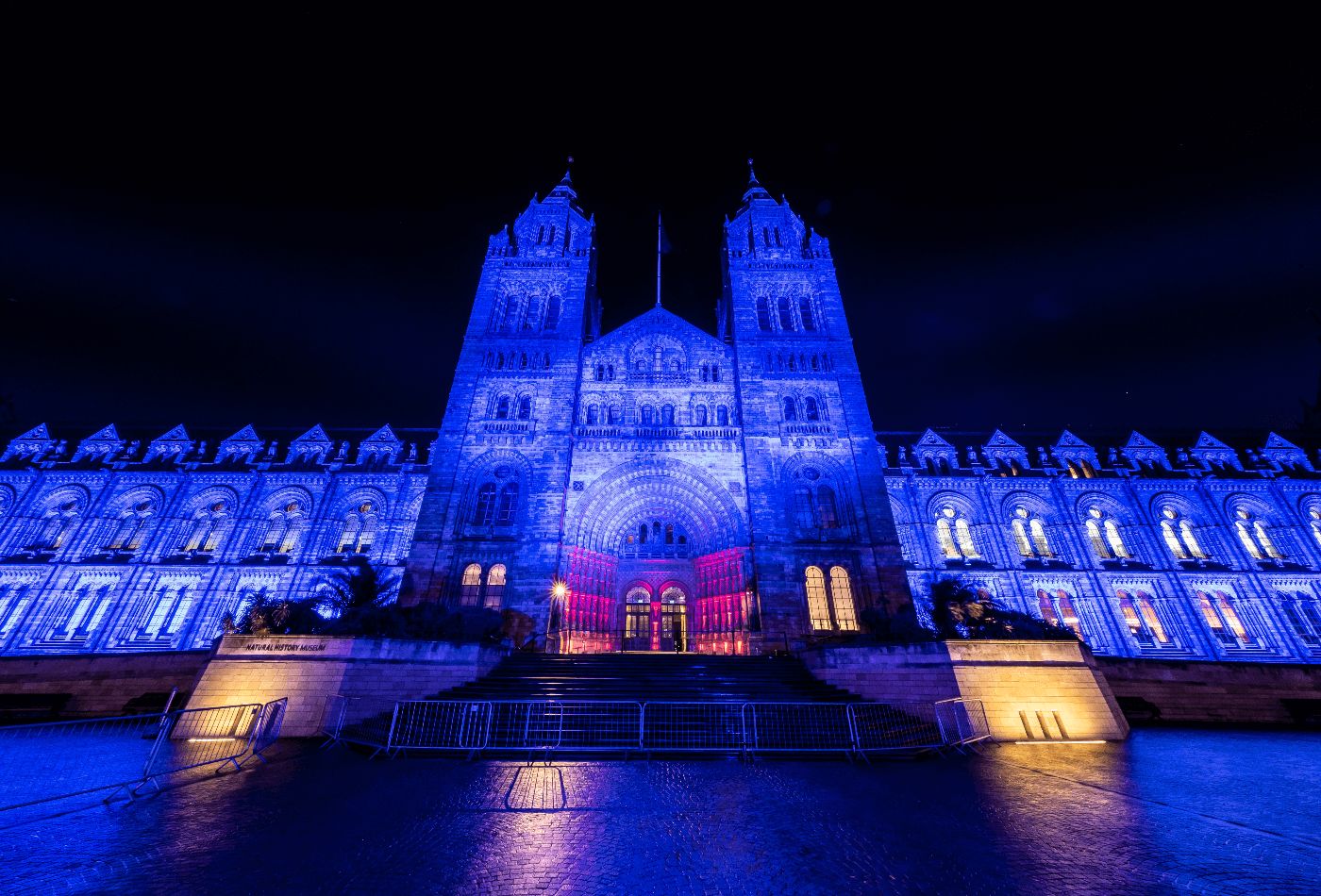 Outdoor shot of natural history museum at night, lit up in blue.jpg