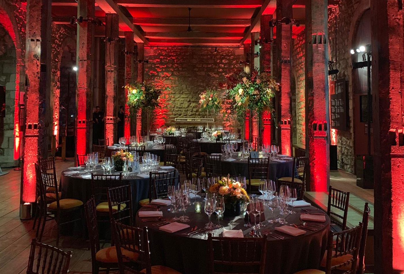 Black themed dinner party with stone walls lit up in red
