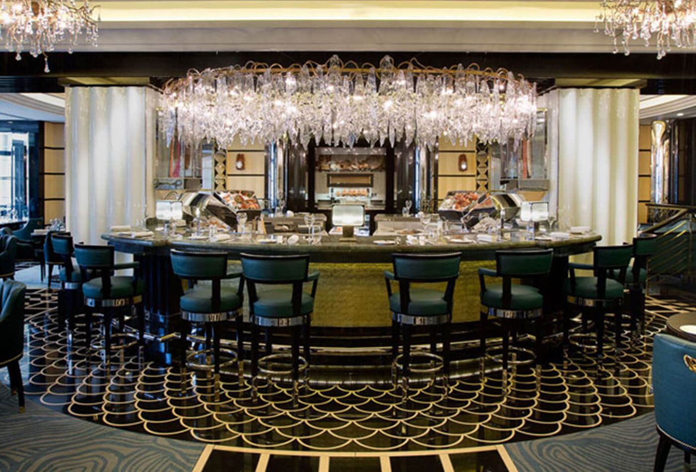 Interior shot of the bar, colour scheme is black and gold with large chandeliers 