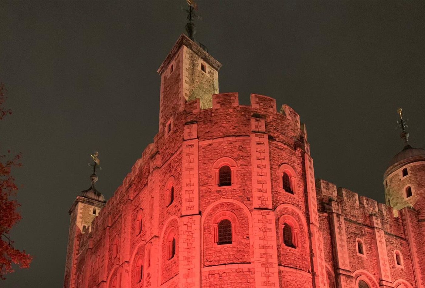 Mighty stone tower at night, lit up in red