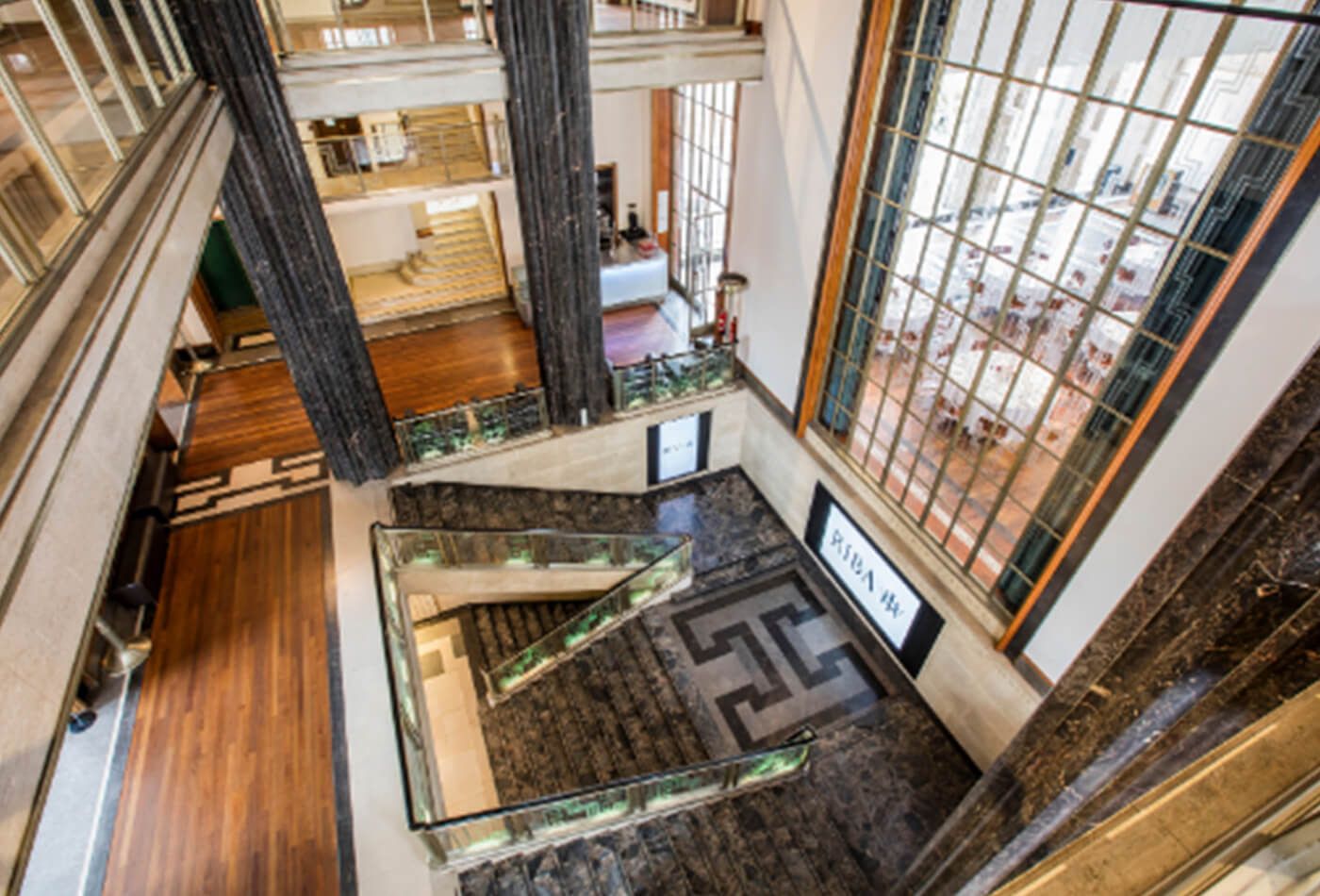 Grand entrance with wood flooring, vast glass windows and lots of stairs