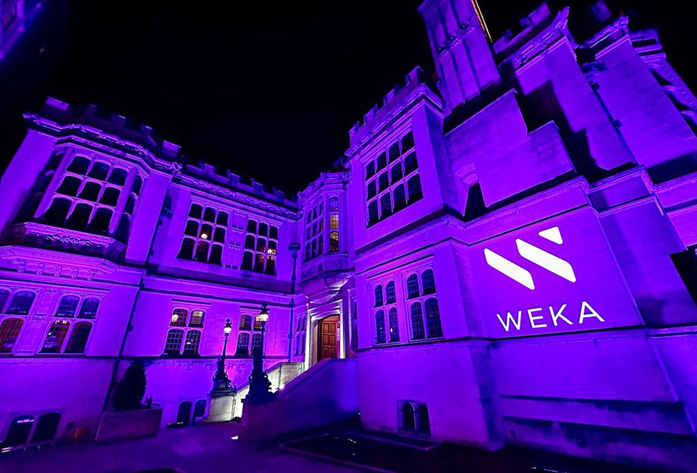 Neo-Gothic mansion at night, lit up in purple