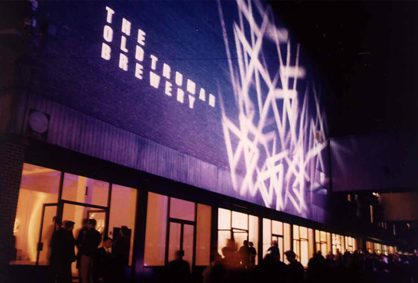 Outdoor shot of concrete building at night with abstract art projected onto the wall