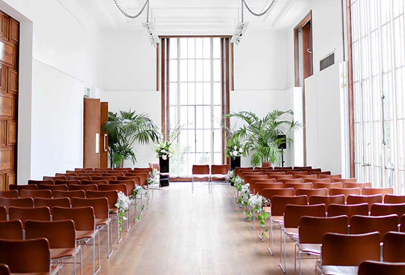 Conference room with brown leather chairs and tall plants